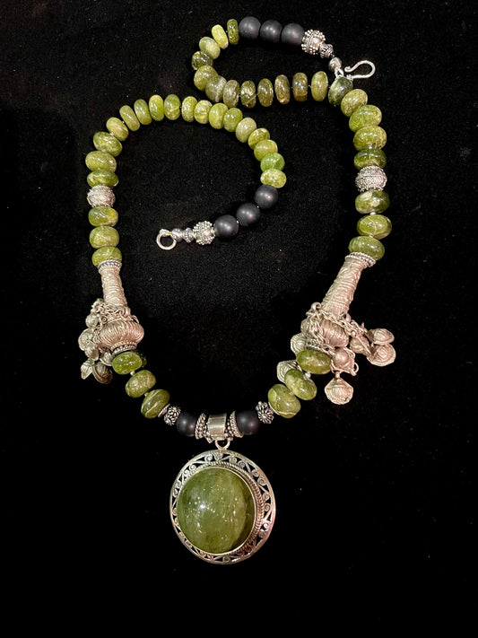 Prehensile and silver pendant, strung with green garnets, matte black agates, old silver