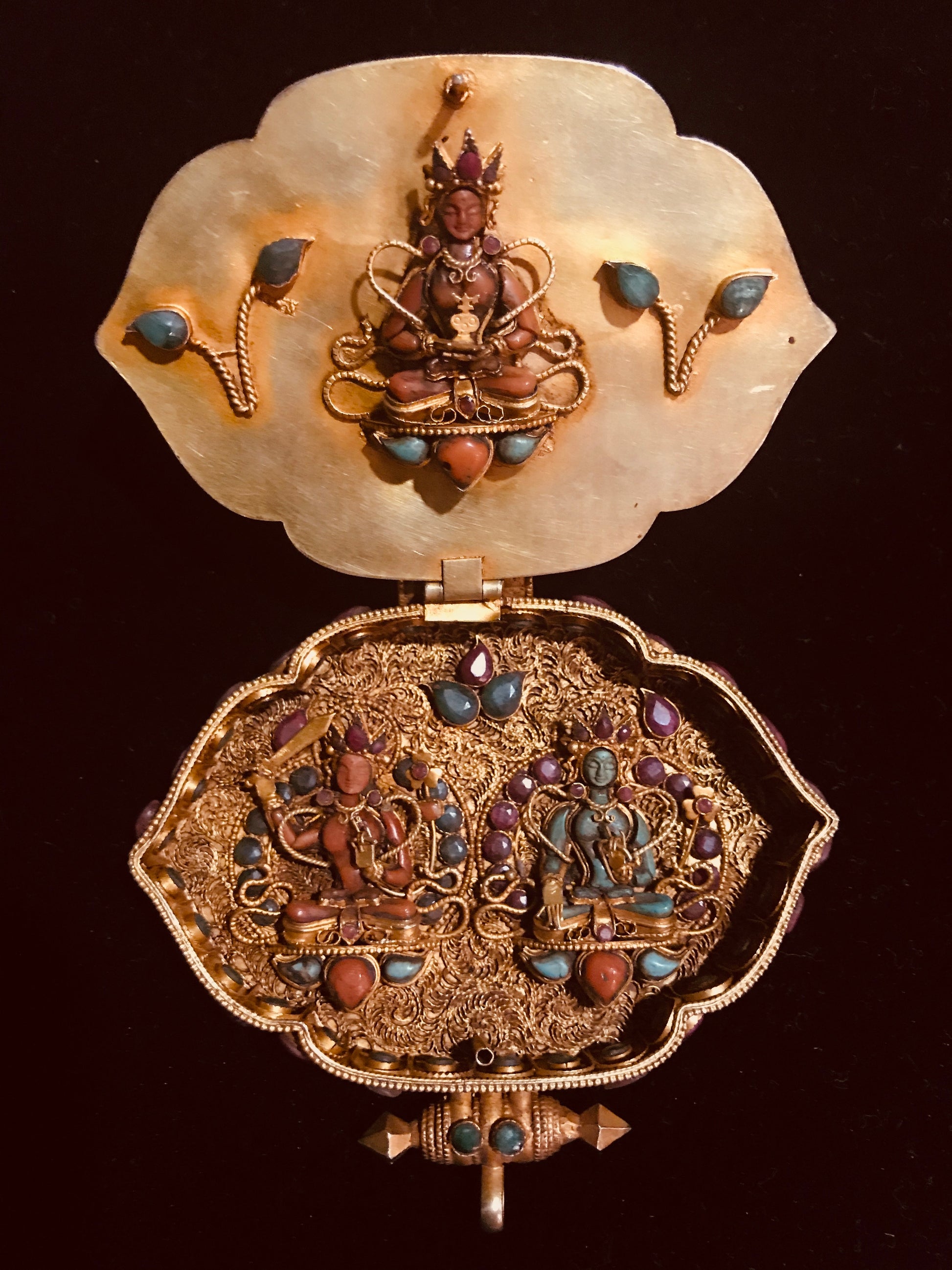 The Open Gau displays a figure of the goddess Tara using coral and emerald, On the  inside of the Gau are 2 figures of deities - one of coral and the other of emeralds